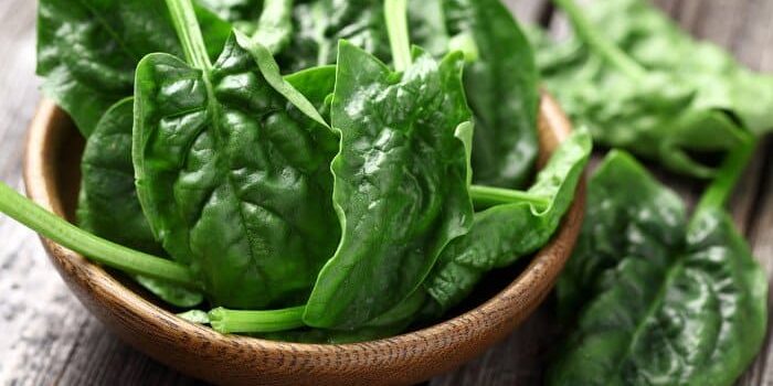 Lose Spinatblätter in einer hölzernen Schale