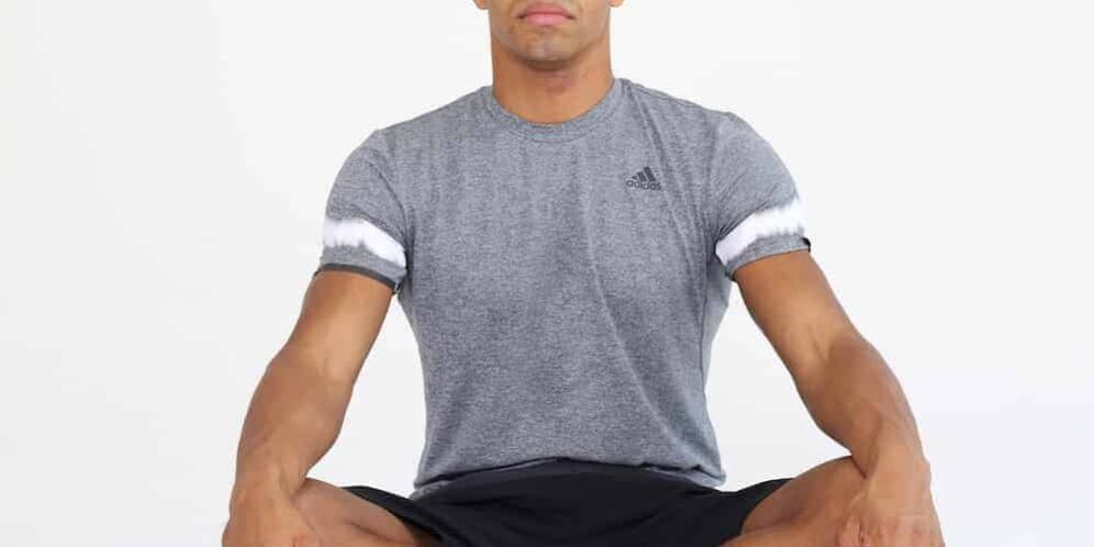 Rückengesundheit Entspannung Mann sitzt im Schneidersitz mit geschlossenen Augen und entspannt sich