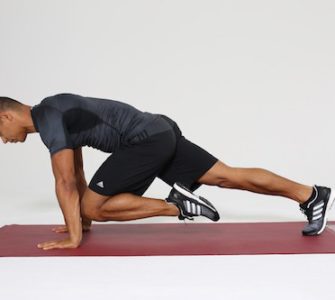 Mann macht Mountain Climbers auf dunkelroter Trainingsmatte