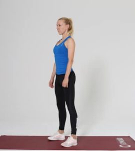 Frau macht Squat Ausgangsposition auf roter Trainingsmatte