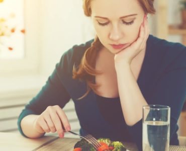 Frau stochert lustlos im Salat