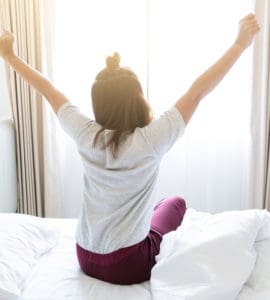 Morgen Routine - Frau räkelt sich im Bett nach dem Aufstehen