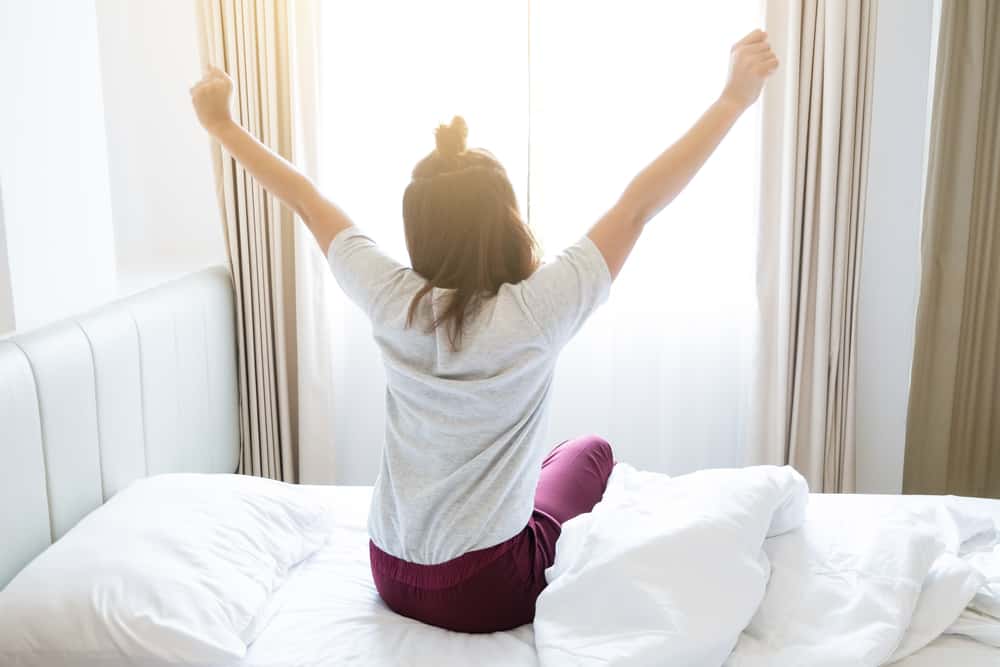 Morgen Routine - Frau räkelt sich im Bett nach dem Aufstehen