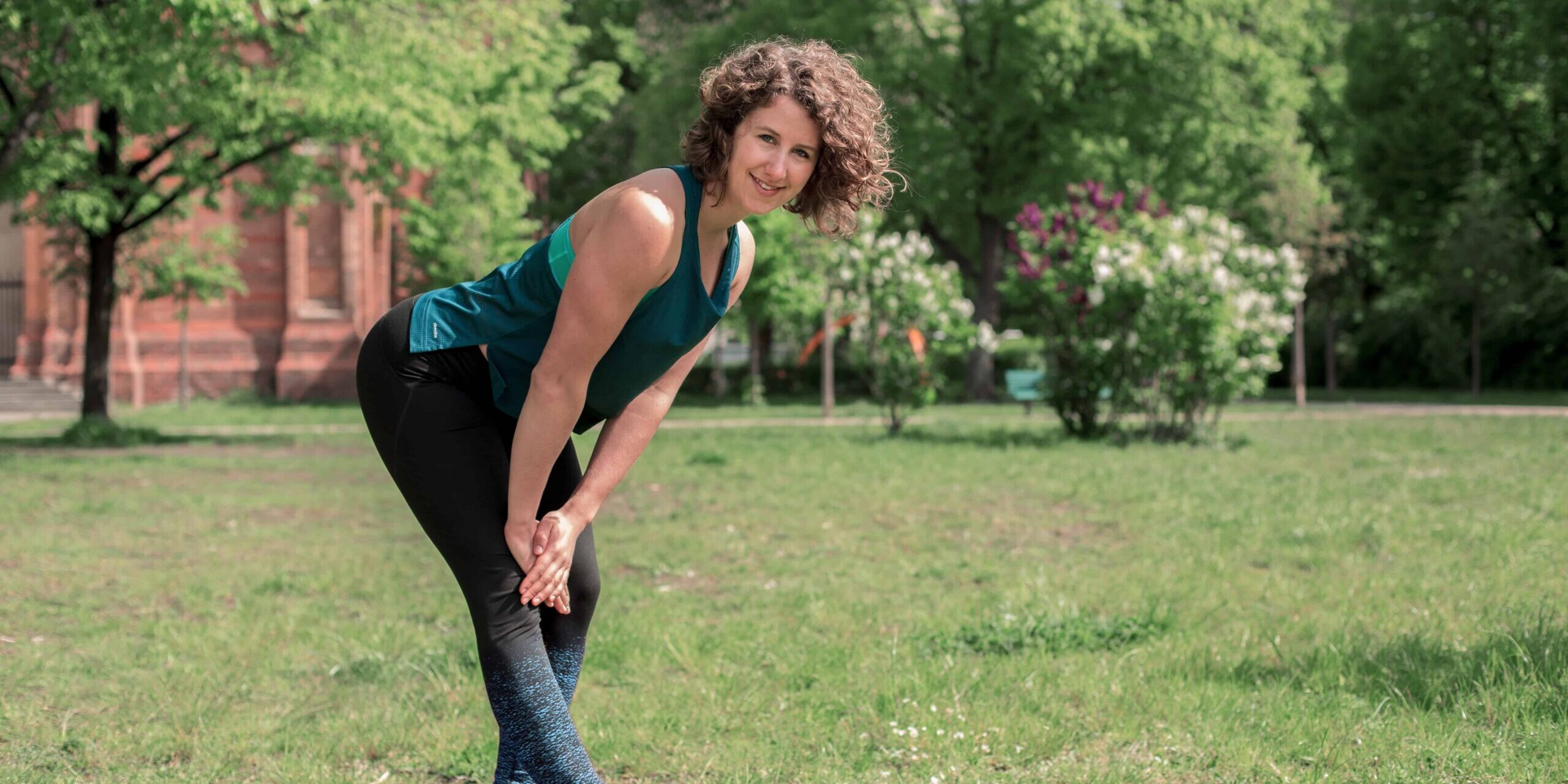 Bein Stretch Junge Frau auf einer Raststätte macht Übung Bein Stretch