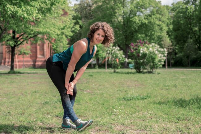 Junge Frau auf einer Raststätte macht Übung Bein Stretch