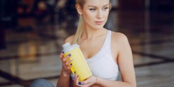 Fitness Girl mit Supplement Shaker Nahrungsergänzung