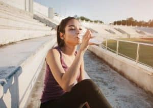 Sportlerin trinkt Wasser nach dem Workout.