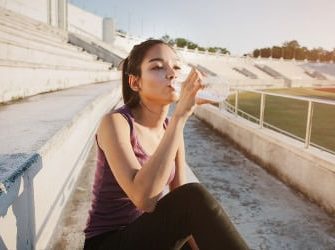 Sportlerin trinkt Wasser nach dem Workout.