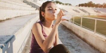 genug-wasser-trinken Sportlerin trinkt Wasser nach dem Workout.