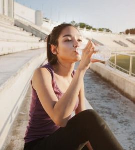 Sportlerin trinkt Wasser nach dem Workout.