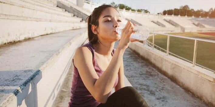 Sportlerin trinkt Wasser nach dem Workout.