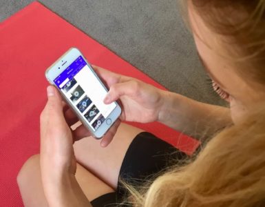 Junge Frau auf roter Trainingsmatte testet Gymondo App