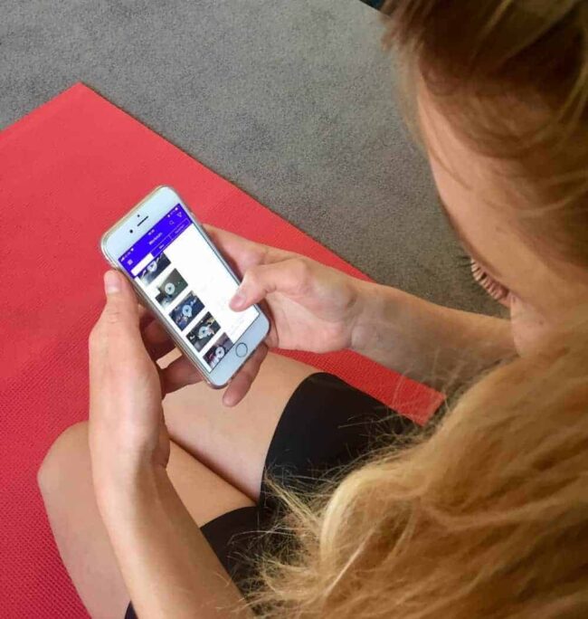 Gymondo Erfahrung – Online Fitness im Praxis Test Junge Frau auf roter Trainingsmatte testet Gymondo App