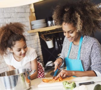 Mutter und Kind kochen gemeinsam gesund in der Küche