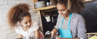 Mutter und Kind kochen gemeinsam gesund in der Küche