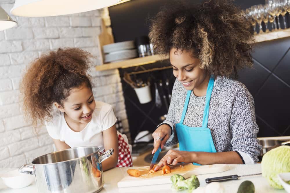 Mutter und Kind kochen gemeinsam gesund in der Küche