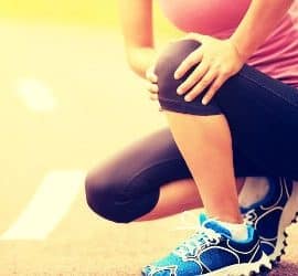 Sportlerin fasst sich ans Knie
