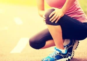 Sportlerin fasst sich ans Knie