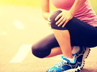 Sportlerin fasst sich ans Knie