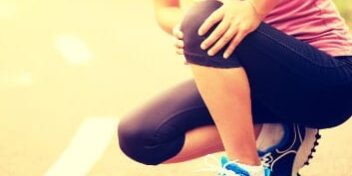 Sportlerin fasst sich ans Knie