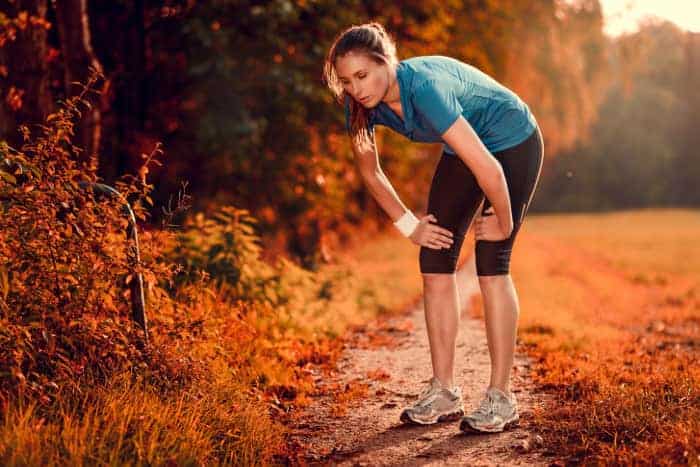 Sportlerin im Wald außer Atem: Erschöpfung durch Laktat
