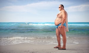 Einsamer Mann mit Bierbauch am Strand