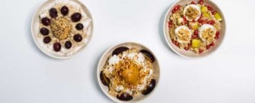 3 weiße Schalen mit Haferbrei garniert mit Früchten und Nüssen, Oat Meal Bowls