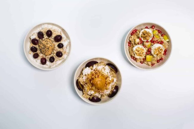 3 weiße Schalen mit Haferbrei garniert mit Früchten und Nüssen, Oat Meal Bowls