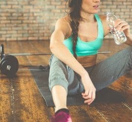 Sportlerin trinkt Wasser um abzunehmen