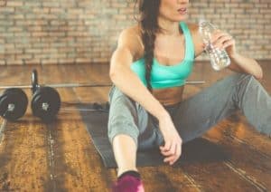 Sportlerin trinkt Wasser um abzunehmen