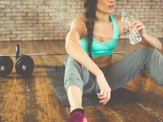 Sportlerin trinkt Wasser um abzunehmen