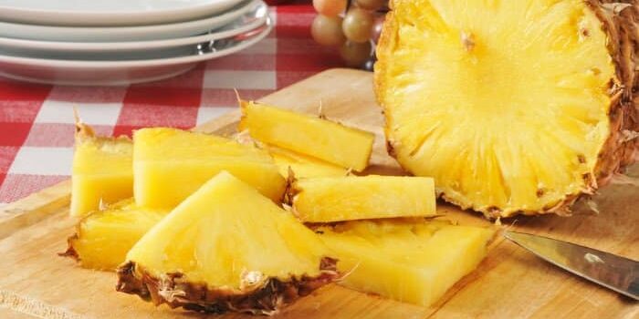 Geviertelte Ananasscheiben auf einem Holzbrett