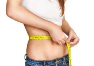 Frau misst Fett am Bauch