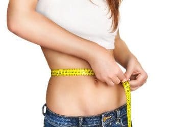 Frau misst Fett am Bauch