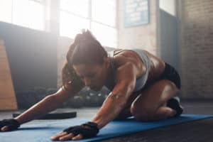 Junge, athletische Frau macht Yoga für Sportler - die Haltung des Kindes