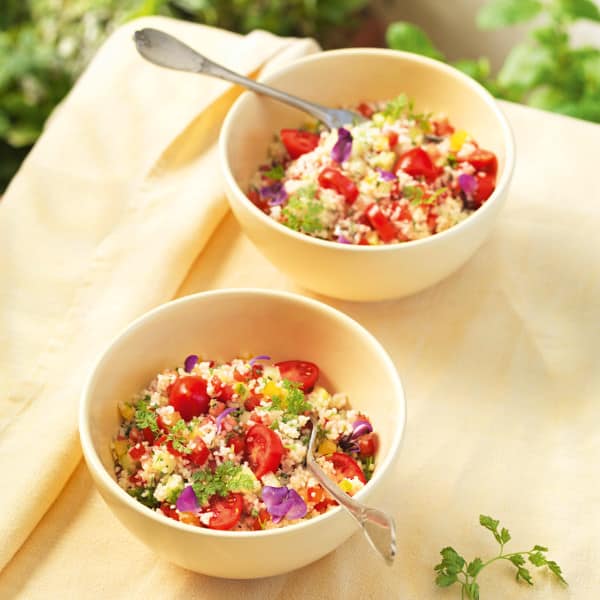 Zwei Schüsseln Couscous-Salat mit Tomate und Zwiebel