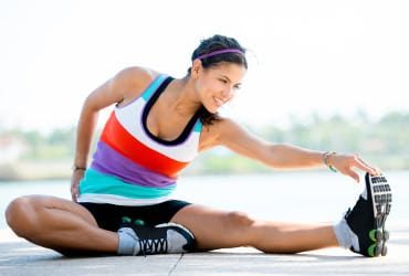 Diese Frau dehnt sich nach dem Sport, um Dysbalancen vorzubeugen.