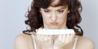 diaetstress_314 Frau schaut verärgert auf ein Maßband