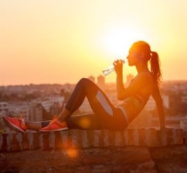 Sportlerin sitzt auf Mauer