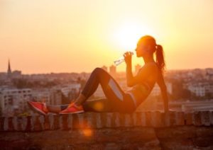 Sportlerin sitzt auf Mauer