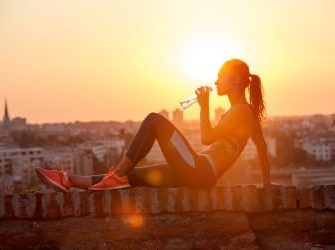 Sportlerin sitzt auf Mauer