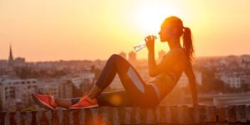 fitness girl Sportlerin sitzt auf Mauer