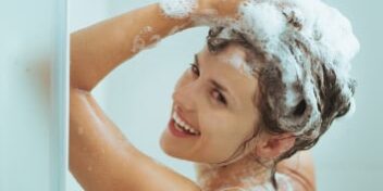 frau-duscht_353 Duschende Frau beim Einshampoonieren ihrer Haare