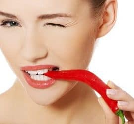 Frau mit Chilischote: Natürliche Antibiotika in Lebensmitteln