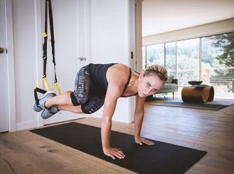 Sportlerin mit dem TRX im Wohnzimmer