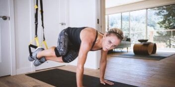 gymondo trx 353 Sportlerin mit dem TRX im Wohnzimmer