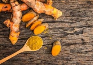 Kurkuma Wurzel aufgeschnitten und als Pulver