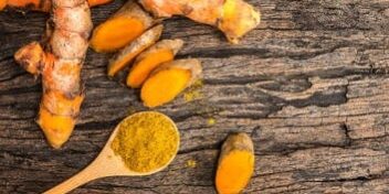 Kurkuma Wurzel aufgeschnitten und als Pulver