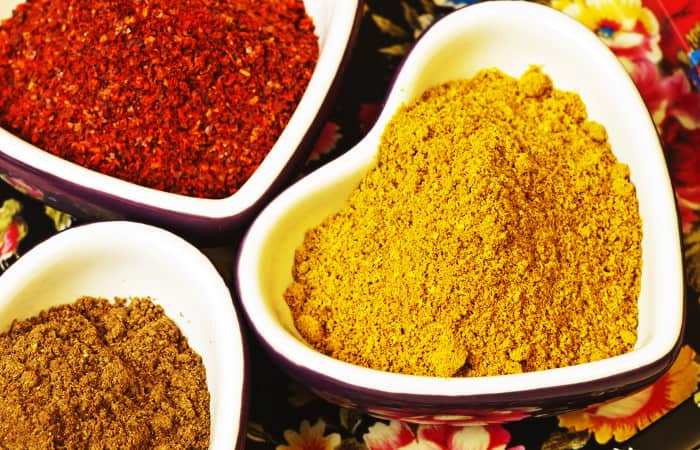 Gelber und roter Kurkuma in herzförmiger Keramikschüssel