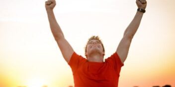 motivation-mann-jubelt-sonnenuntergang_353 Mann streckt die Arme in die Höhe